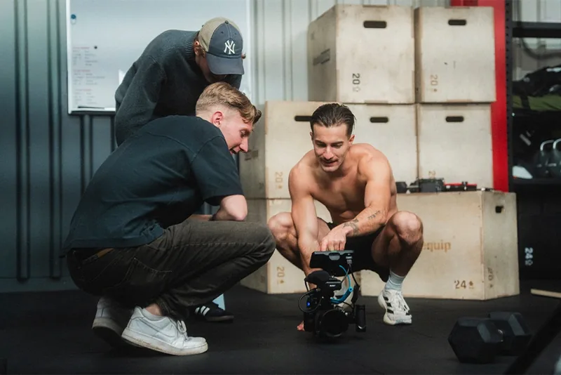 Behind the scenes of a social campaign shoot: Lua Hell and the team reviewing a take on the camera monitor between setups