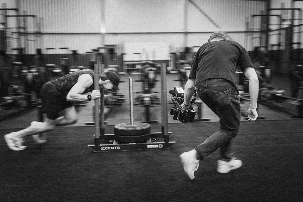 Behind the scenes from Beyond Performance documentary: athlete Dariell Heim running on a curved treadmill during a Zurich gym shoot, directed by Lua Hell