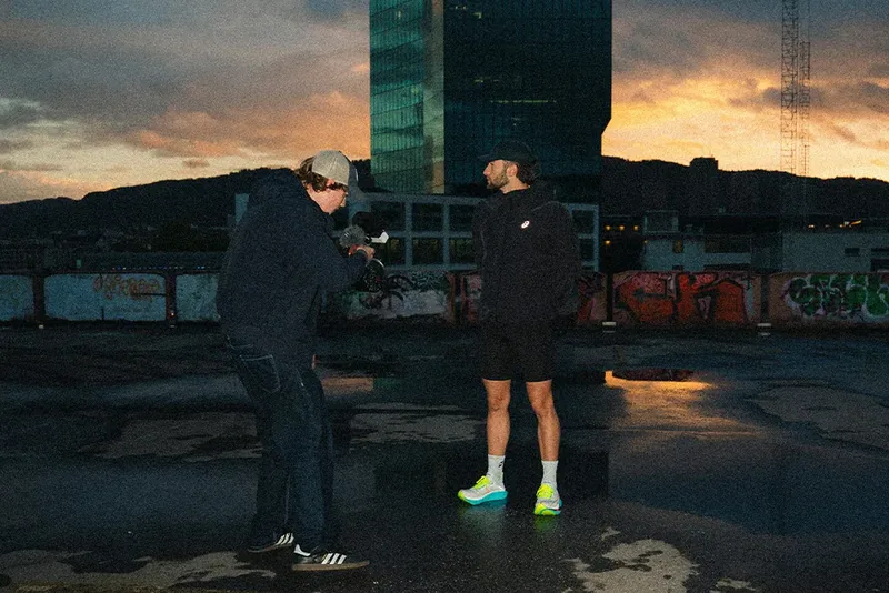 Behind the scenes of the Saucony The Run commercial: Lua Hell filming the athlete handheld on a Zurich rooftop at sunrise